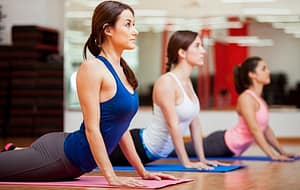 women stretching on mats in a workout room